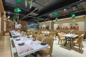 a dining room with white tables and chairs at Hotel Vivanta Inn Somnath in Somnath