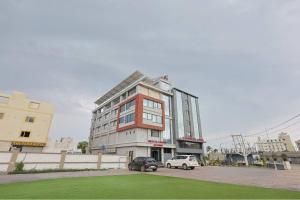 a building with two cars parked in front of it at Hotel Vivanta Inn Somnath in Somnath