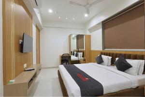 a hotel room with a bed and a television at Hotel Vivanta Inn Somnath in Somnath