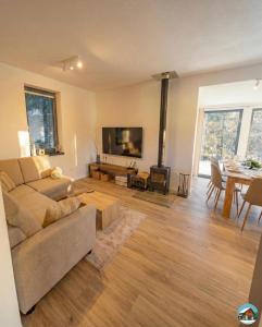 a living room with a couch and a tv and a table at Chata Hrbánik Tále in Bystrá