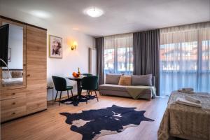 a bedroom with a bed and a table and a couch at Apart Hotel Dream in Bansko