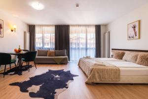 a bedroom with a large bed and a living room at Apart Hotel Dream in Bansko