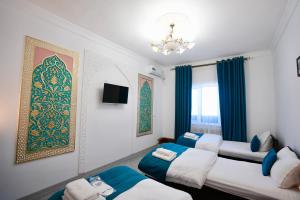 a room with two beds and a chandelier at RAY Boutique Hotel withTerrace in Bukhara