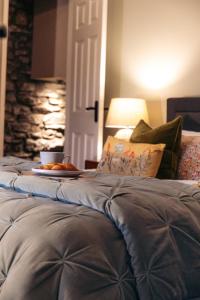 a bed with a plate of food on top of it at 4 Walkers Cottage - Cosy, dog friendly with private unique BBQ hut! in Pont Sticill