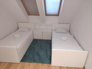 a room with two beds in a small room at Hostel i Restoran SEQUOIA in Slatina