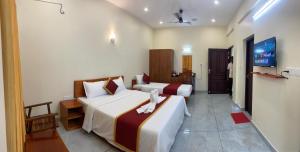 a hotel room with two beds and a hallway at Siva Bharg Residency in Kovalam