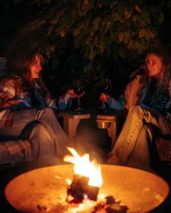 a group of three women sitting around a fire at 4 Walkers Cottage - Cosy, dog friendly with private unique BBQ hut! in Pont Sticill +17 photos