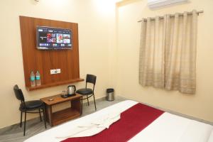 a room with a bed and a table and chairs at Hotel Relax in Jaipur