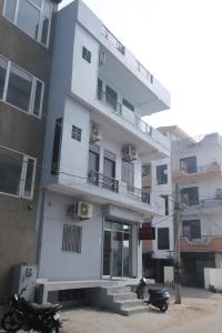 a white building with two motorcycles parked in front of it at Hotel Relax in Jaipur