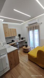 a kitchen and living room with a yellow bed in a room at Lūma Retreat in Kastoria