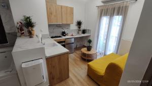 a kitchen and living room with a yellow couch at Lūma Retreat in Kastoria +10 photos