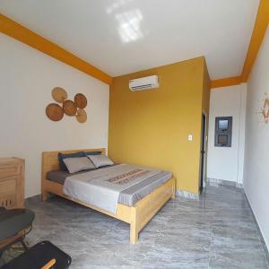 a bedroom with a bed and a yellow wall at NT Bell Homestay in Ninh Hải