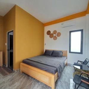 a bedroom with a bed and a yellow wall at NT Bell Homestay in Ninh Hải
