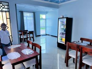 a man standing in a dining room with a refrigerator at ANITHA EXECUTIVe LODGE in Kibaha