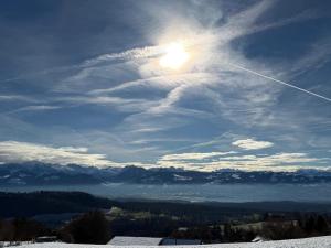 a view of the sun from the top of a mountain at Panorama-Chalet Unterbach in Hinwil