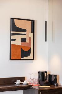 ein Gemälde, das an einer Wand über einer Küchentheke hängt in der Unterkunft Sunrise Hotel in Ireo