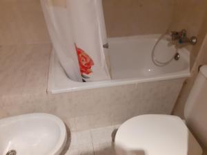 a bathroom with a toilet and a sink and a tub at Hostal RIAÑO TANIS in Riaño