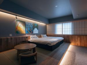 a bedroom with a bed and a table in it at Experience Ise Miyamachi Hotel in Ise +57 photos