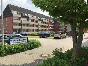 a hotel parking lot with a sign in front of a building at Ruhige See in Borkum