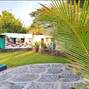 a house with a palm tree in front of a yard at Arpan Villa in Aurangabad