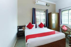 a bedroom with a large bed with red pillows at Capital O The Tulip in Rānchī