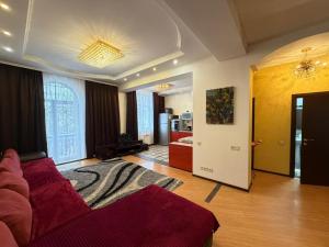 a large living room with a red couch and a living room at Abylai Khan 113 Central in Almaty