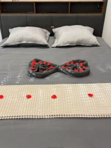 a pair of shoes on a bed with hearts on it at Jacuzzi Privé & Cinéma - Suite Romantique in Essey-lès-Nancy
