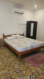 a bed sitting in a room with a mirror at Rooms in Apo-estin in Cangatuyom
