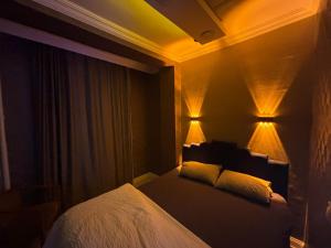 a bedroom with a bed and two lights on the wall at Çankaya Otel in Altındağ