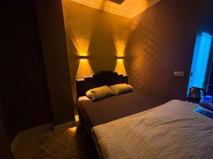 a bedroom with two beds with lights on the wall at Çankaya Otel in Altındağ +1 photo