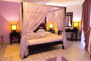 a bedroom with a canopy bed with mosquito nets at Familly Art Hotel Nirvana in Shumen