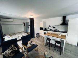 a room with a bed and a table and chairs at Le repaire du raton laveur in Rance +18 photos
