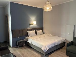 a bedroom with a large bed with a blue wall at Le Bijou Luxury Rooms & Suites in Veria