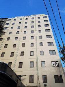 Un grand bâtiment blanc avec de nombreuses fenêtres. dans l'établissement Hotel Crown Hills Kumamoto, à Kumamoto