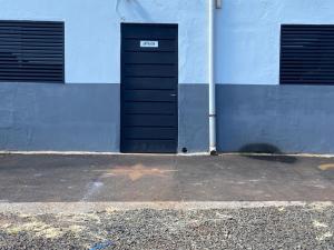 a building with a black door and two windows at Loft San Isidro in Ciudad del Este