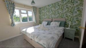 a bedroom with a bed with a cat sitting on it at Family-run 5 Star Home - Consistent Superhosts in Long Lawford