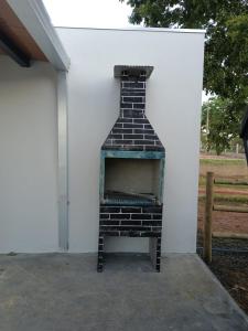 a brick oven sitting next to a white wall at Kabana Harmony in Aquidauana