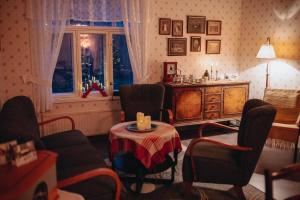a living room with chairs and a table and a window at Sundholms Gård - Sundholmin Tila in Kokkola