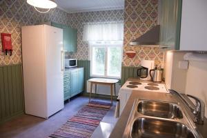 a kitchen with green cabinets and a white refrigerator at Sundholms Gård - Sundholmin Tila in Kokkola +15 photos