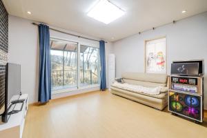 a living room with a couch and a tv at Yangpyeong Narinsoom Private Villa in Yangpyeong