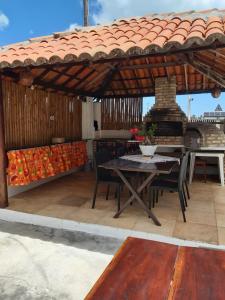 a table and chairs on a patio with a grill at Casa Bete e Farouk in São Miguel do Gostoso