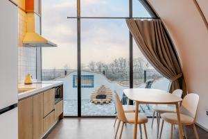 a kitchen with a table and chairs and a large window at Ganghwa Aiem Glamping in Incheon +24 photos