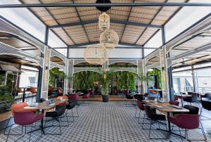 a restaurant with tables and chairs and windows at Vértice Sevilla Aljarafe in Bormujos