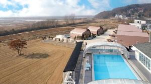 an aerial view of a farm with a pool and a field at Ganghwa Aiem Glamping in Incheon