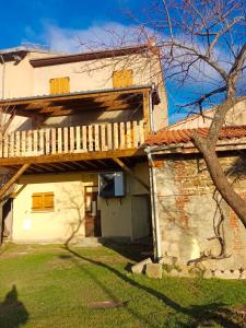 an external view of a house with a wooden deck at La petite Maison in Vézézoux