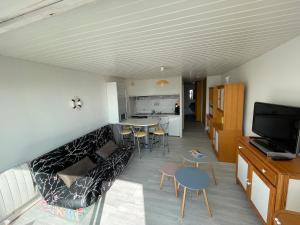 a living room with a couch and a table at Cocon Marin 2 Etoiles - Face Océan et Balcon in Fort-Mahon-Plage