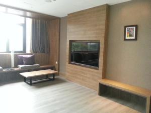sala de estar con TV de pantalla plana en la pared en Imperial Dynasty Boutique Hotel en Dounan