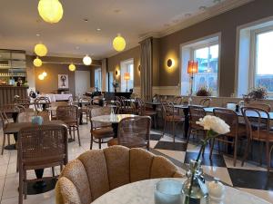 a restaurant with tables and chairs and windows at Grand Hotel Jonkoping, BW Signature Collection in Jönköping
