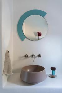 a bathroom sink with a round mirror above it at Seriphos Estate in Serifos Chora +74 photos