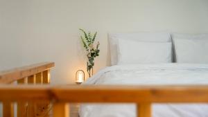 a bedroom with a white bed and a vase of flowers at Goseong Jajackdo Aroma Pension in Goseong +10 photos